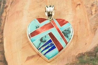 Stunning Heart Pendant featuring Genuine Turquoise, Spiny Oyster Shell and Blue Lapis inlaid between ribbons of Sterling Silver. Beautiful Fire and Ice Lab Opal Accents. Free 18" Sterling Silver Chain with Purchase of Pendant.  Designed by Navajo Artist Calvin Begay. Signed.